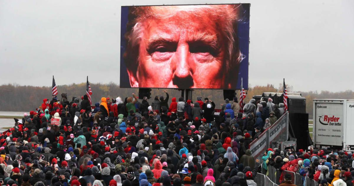 Supporters endure cold rain while waiting for former US President Donald Trump's arrival at a campaign rally at Capital Region International Airport in Lansing, Michigan, on October 27, 2020 (Photo by Chip Somodevilla/Getty Images)