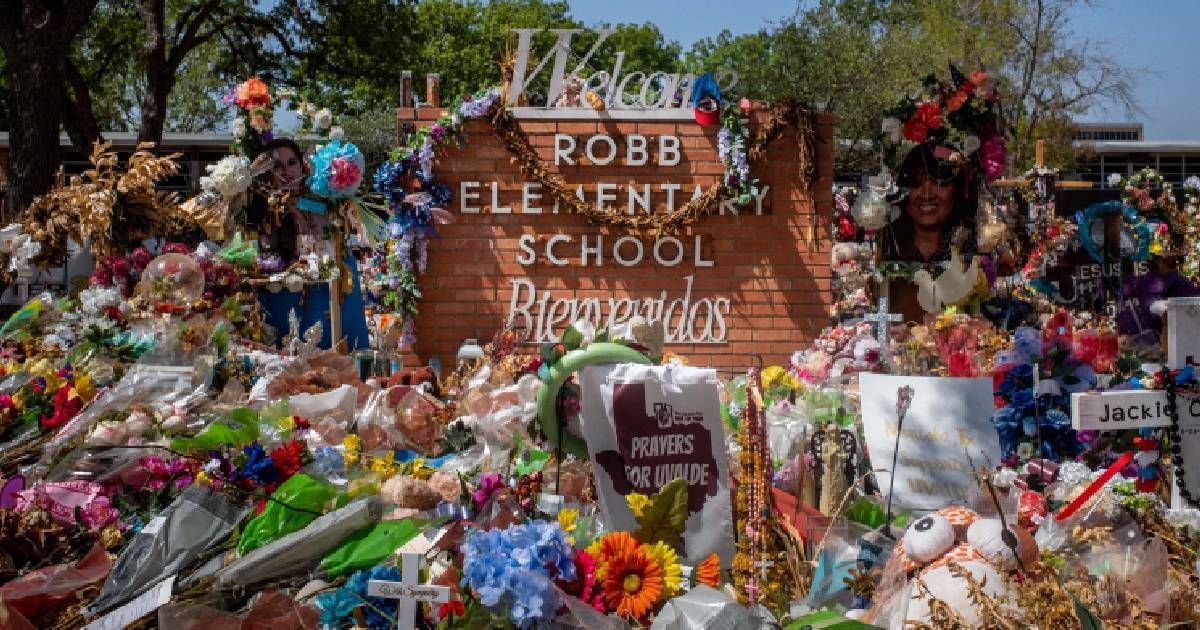 The Robb Elementary School sign is seen covered in flowers and gifts (Getty Images)