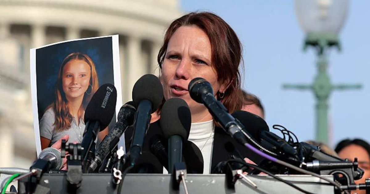 Epstein abuse survivor Jena-Lisa Jones holds up a photo of her younger self during a news conference with lawmakers on the Epstein Files Transparency Act outside the US Capitol on November 18, 2025, in Washington, DC (Heather Diehl/Getty Images)