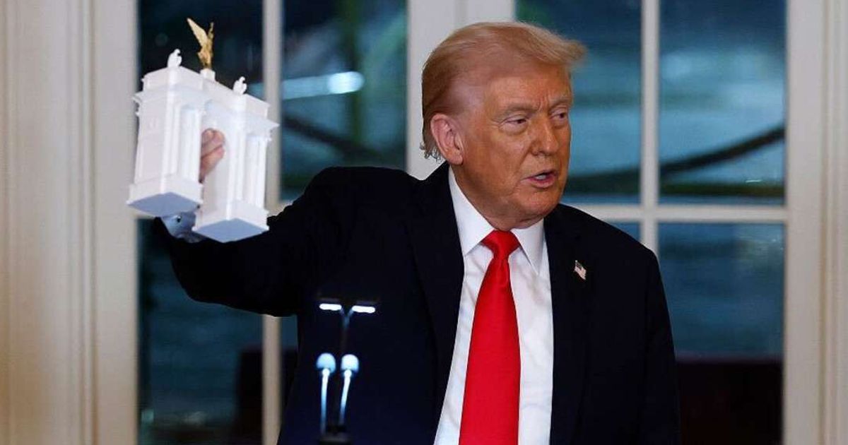 President Donald Trump holds models of an arch as he delivers remarks during a ballroom fundraising dinner in the East Room of the White House on October 15, 2025, in Washington, DC (Kevin Dietsch/Getty Images)