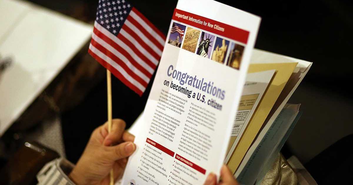 An immigrant holds a brochure about becoming a citizen before being sworn in as a US citizen at a naturalization ceremony at the Paramount Theatre (Justin Sullivan/Getty Images)