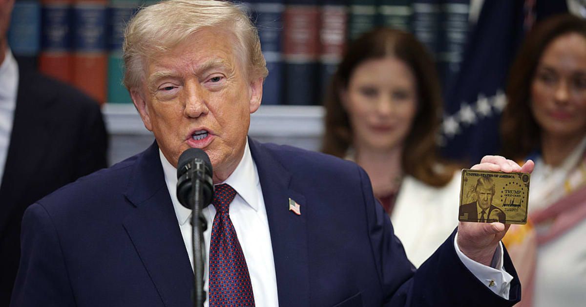 President Donald Trump holds a 'Trump Gold Card' during an event in the Roosevelt Room of the White House on Friday, December 19, in Washington, DC (Alex Wong/Getty Images)