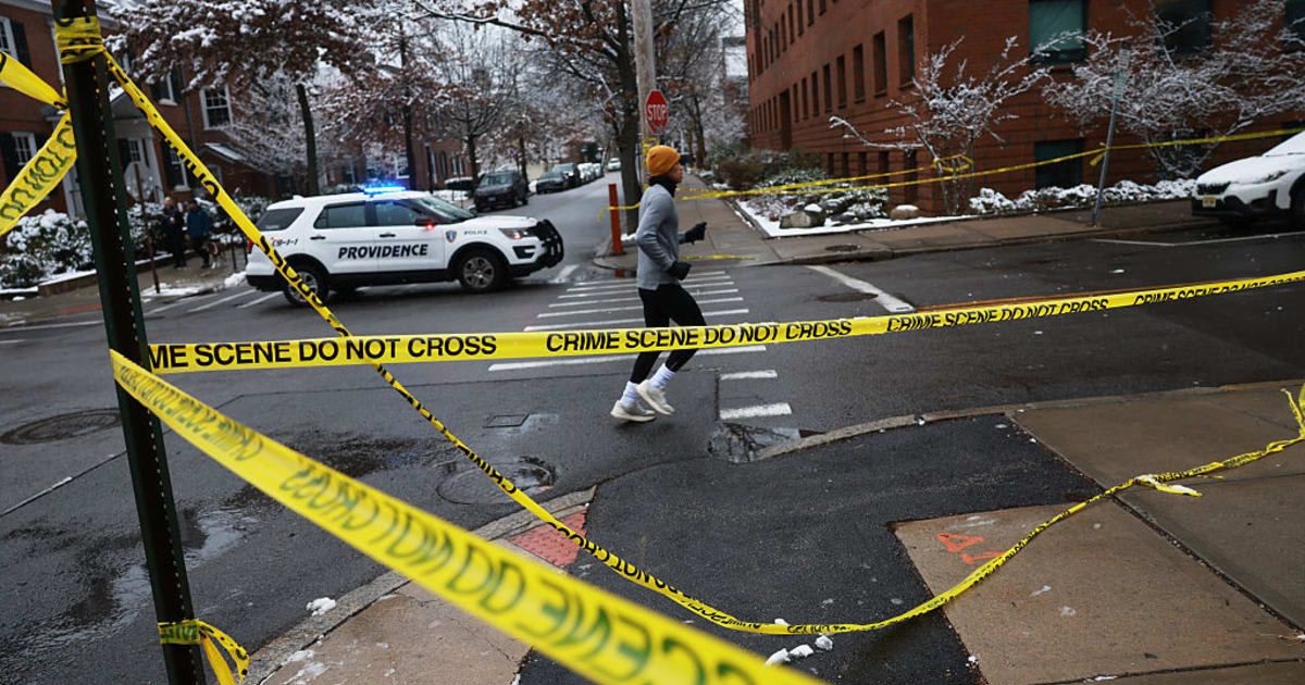 A person jogs by police tape near the campus at Brown University following a mass shooting that left at least two people dead and nine others injured on December 14 in Providence, Rhode Island (Spencer Platt/Getty Images)