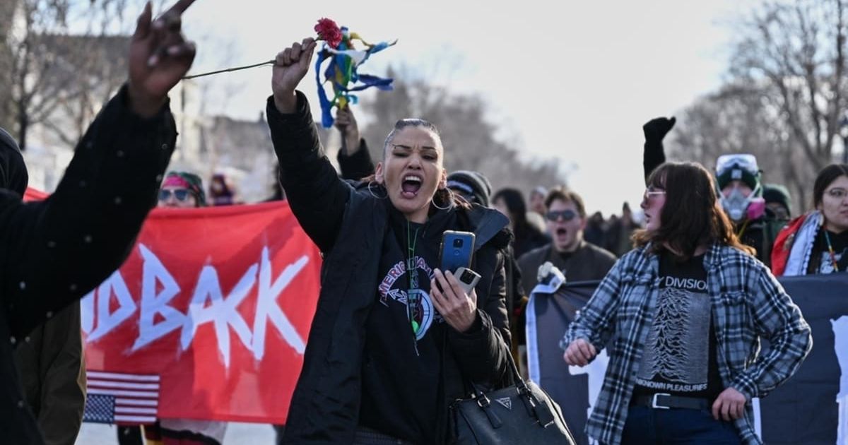 People protest as law enforcement officers attend to the scene of the shooting involving federal law enforcement agents, Wednesday, Jan 7, 2026, in Minneapolis (AP Photo/Tom Baker)