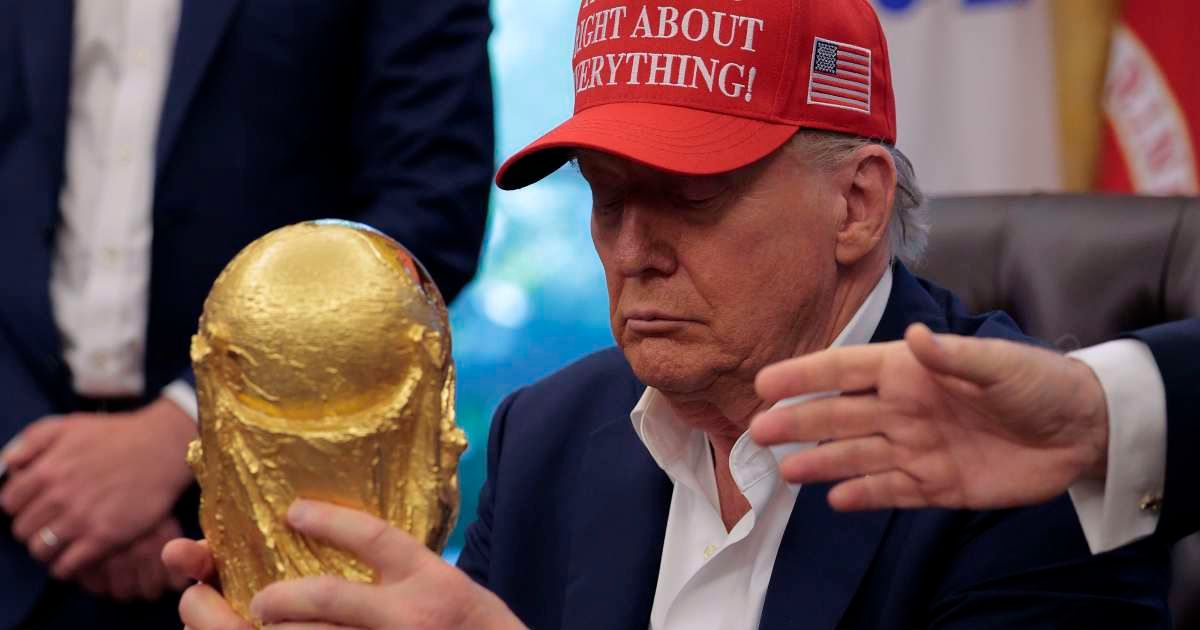 Donald Trump holds the World Cup Trophy in the Oval Office August 22, 2025 in Washington, DC (Chip Somodevilla/Getty Images)