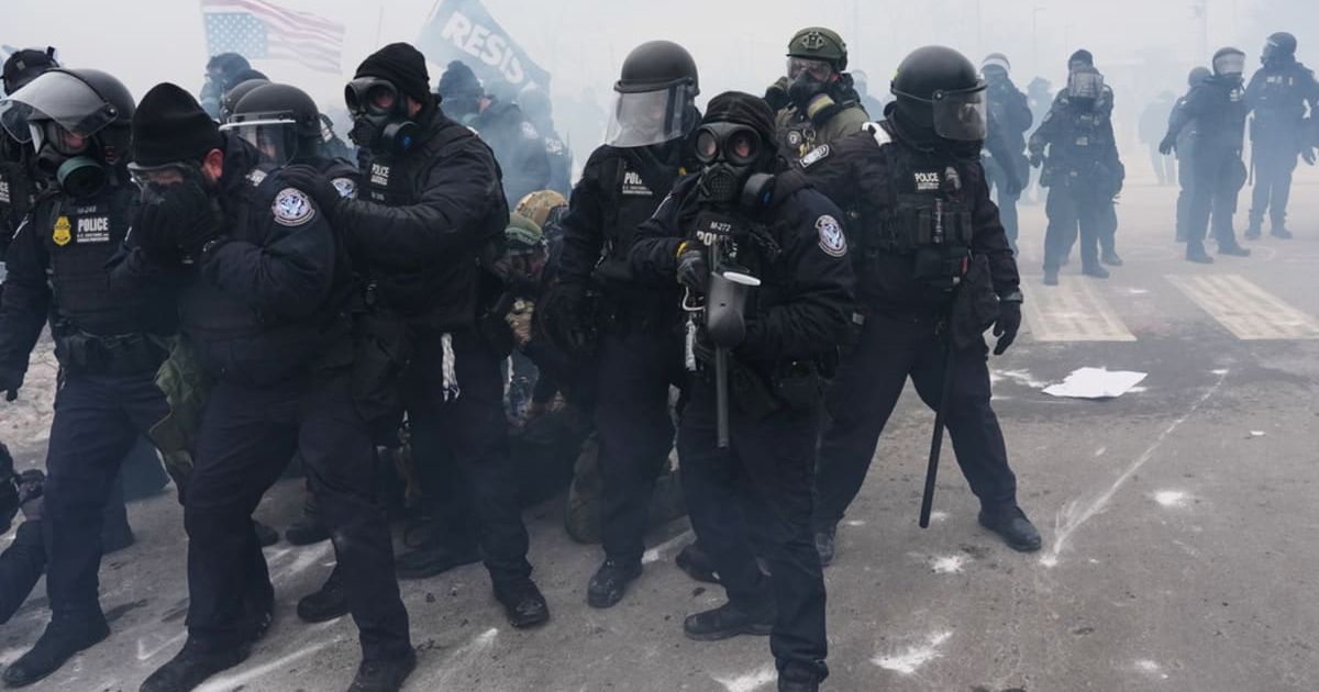 Federal immigration officers confront protesters outside Bishop Henry Whipple Federal Building, Thursday, January 15, 2026, in Minneapolis. (AP Photo/Adam Gray)