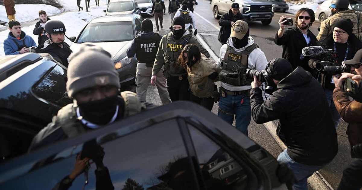 An observer is detained by ICE agents after they arrested two people from a residence on January 13, 2026 in Minneapolis, Minnesota (Getty Images)