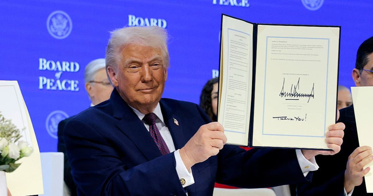 President Donald Trump holds up his signature on the founding charter during a signing ceremony for the 'Board of Peace' at the World Economic Forum (WEF) on January 22, 2026 in Davos, Switzerland (Chip Somodevilla/Getty Images)