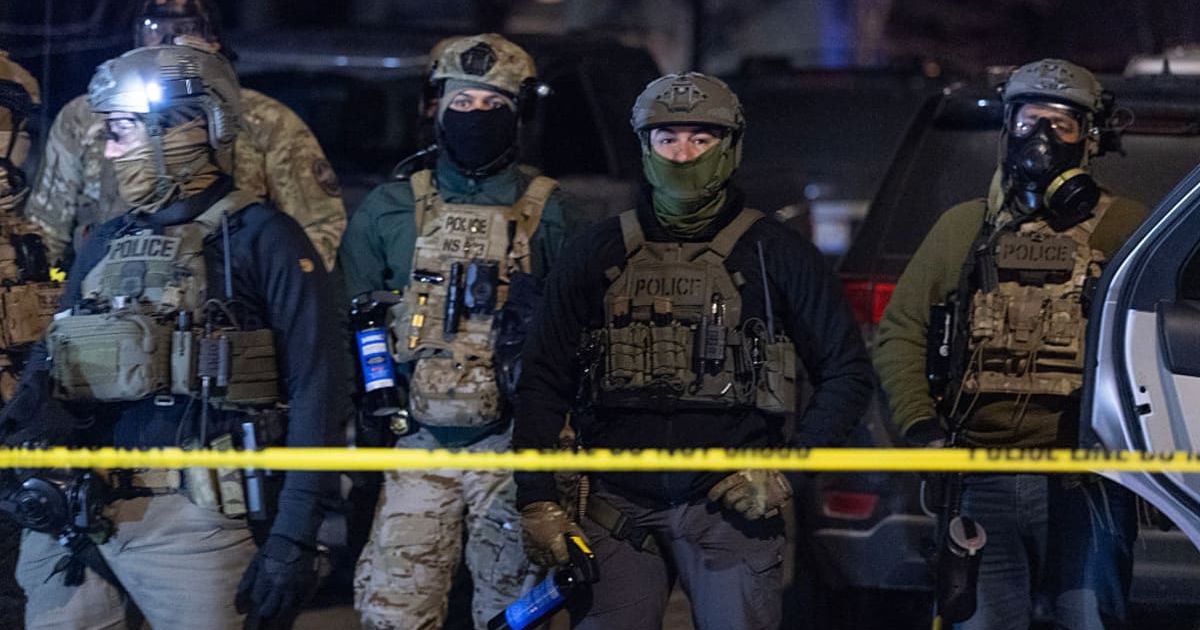 Federal agents guard a perimeter following a shooting incident as angry residents protest their presence in the city on January 14, 2026, in Minneapolis (Getty Images)