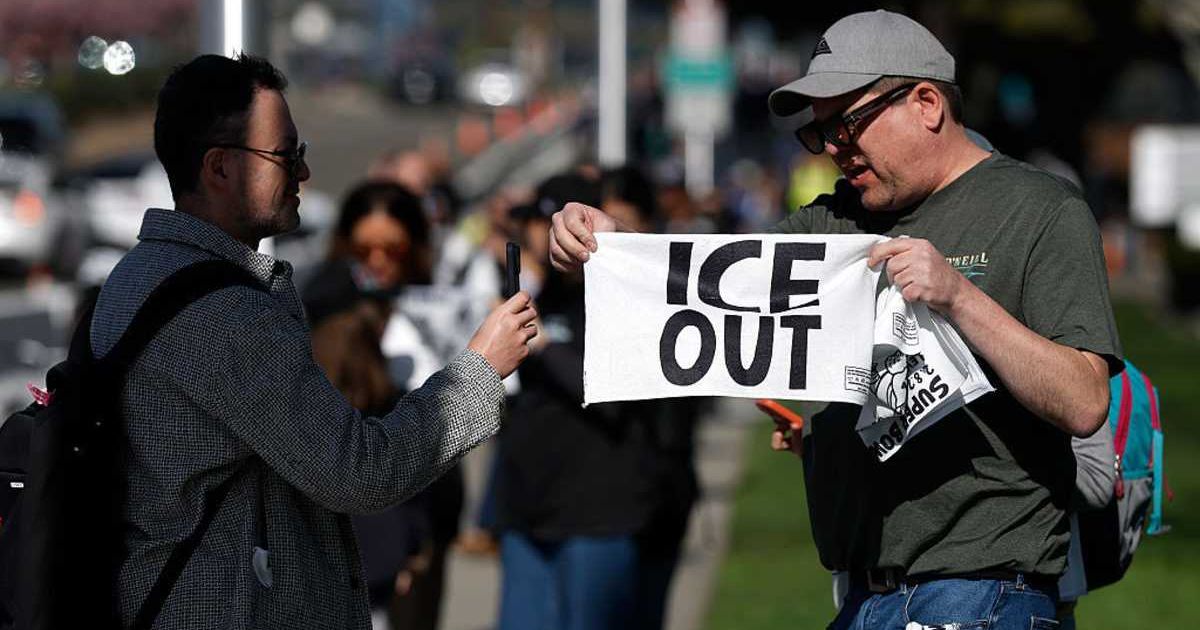 People pass out 'ICE OUT' towels to football fans outside Levi's Stadium before the start of Super Bowl LX on February 8, 2026, in Santa Clara, California (Getty Images)