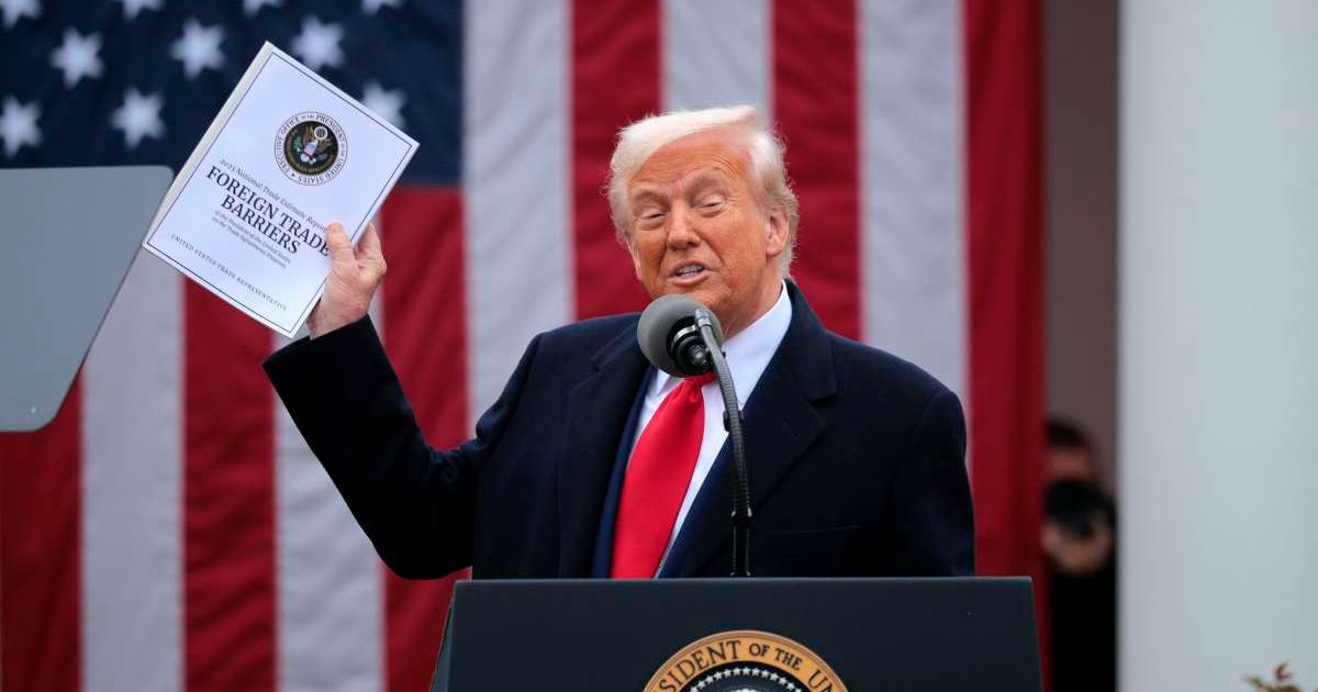 President Donald Trump holds up a copy of a 2025 National Trade Estimate Report as he speaks during a 'Make America Wealthy Again' trade announcement event in the Rose Garden at the White House on April 2, 2025 in Washington, DC (Getty Images) 