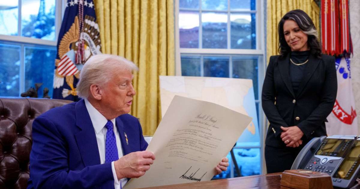 President Donald Trump signs Tulsi Gabbard's commission for her new role as Director of National Intelligence after she was sworn in (Andrew Harnik/Getty Images)