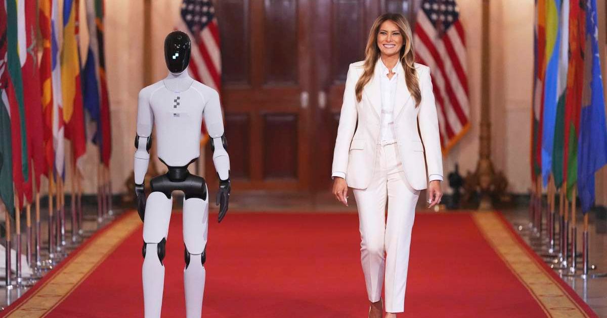 First lady Melania Trump arrives, accompanied by a robot, to attend the 'Fostering the Future Together Global Coalition Summit' at the White House on Wednesday, March 25, 2026, in Washington, DC (AP Photo/Jacquelyn Martin)