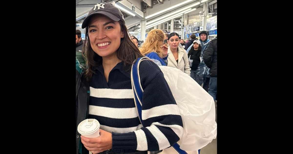 Alexandria Ocasio-Cortez was seen taking selfies as she attended a Yankees game amid shutdown (@am4rrt/X)