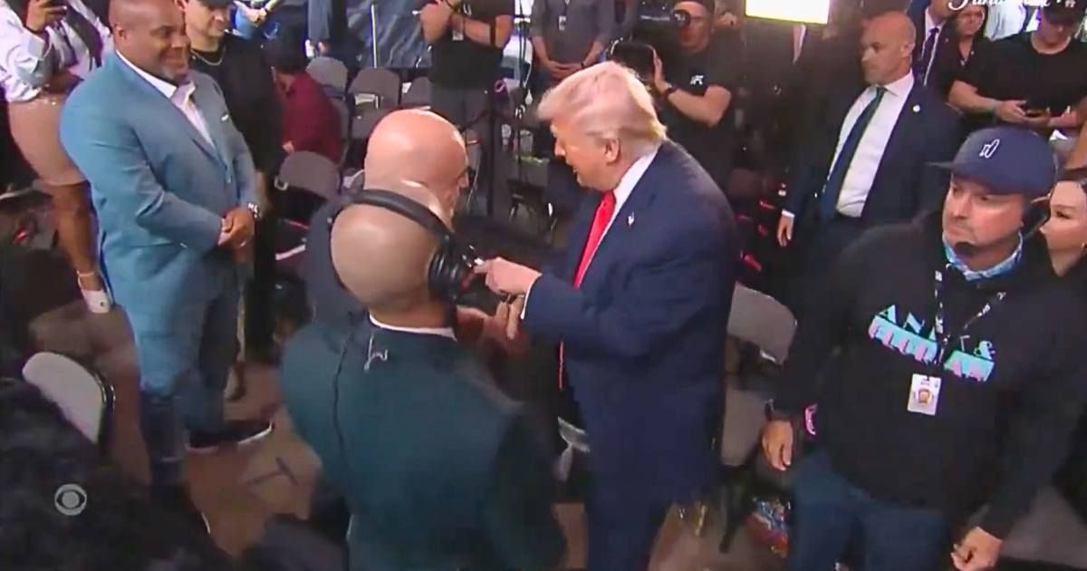 President Donald Trump waved to the crowd and then made a beeline straight for the announcing table, where Joe Rogan was stationed (CBS News)