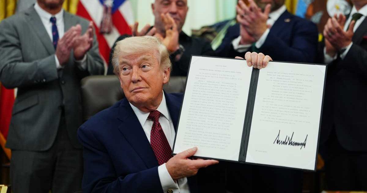 President Donald Trump holds up a signed executive order in the Oval Office of the White House, Saturday, April 18, 2026, in Washington (AP Photo/Julia Demaree Nikhinson)
