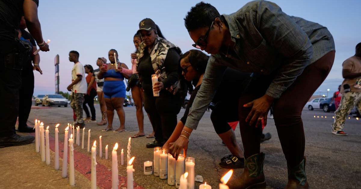 People light candles during a prayer vigil for the victims of a mass shooting earlier in the day, Sunday, April 19, 2026, in Shreveport, Louisiana (AP Photo/Gerald Herbert)