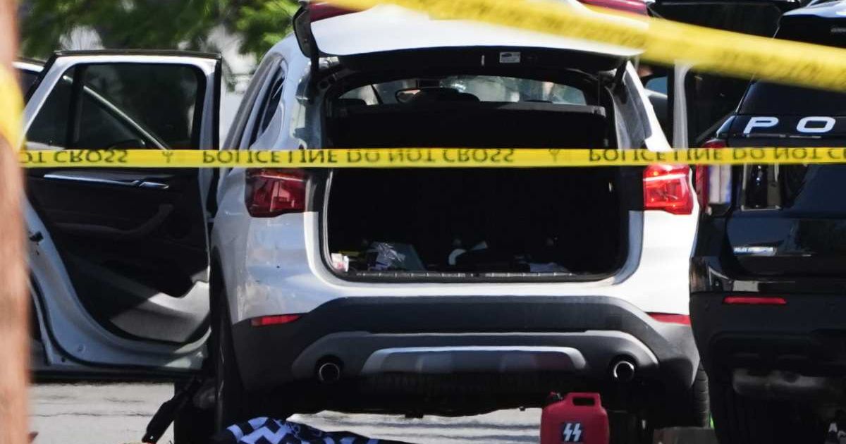 A vehicle's hatch and doors are opened near where a body of one of the shooters was placed at the scene of a shooting outside the Islamic Center of San Diego, Monday, May 18, 2026, in San Diego (AP Photo/Gregory Bull)