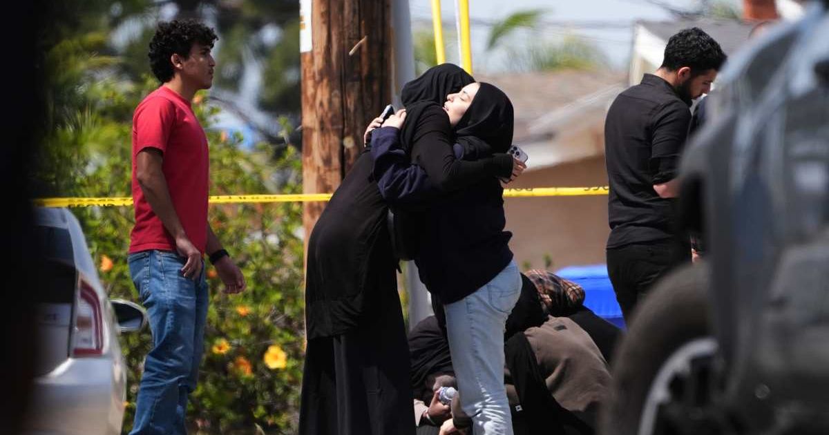 People embrace near the scene of the shooting outside the Islamic Center of San Diego, Monday, May 18, 2026, in San Diego (AP Photo/Gregory Bull)
