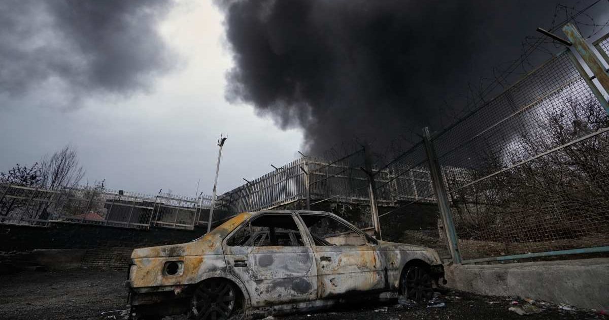 A thick plume of smoke rises from an oil storage facility hit by a US-Israeli strike late Saturday in Tehran, Iran, Sunday, on March 8, 2026 (AP Photo/Vahid Salemi)