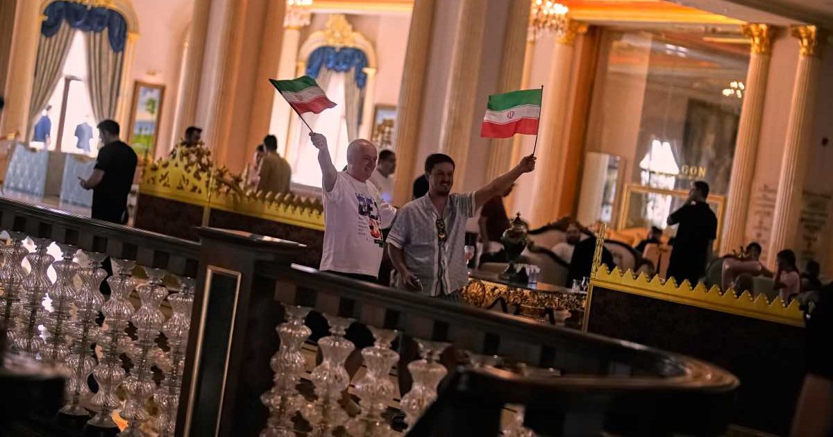 Supporters wave Iranian flags as the team's players leave to Antalya airport, southern Turkey, before departing to Tijuana, Mexico, for the World Cup soccer tournament (AP Photo/Khalil Hamra)