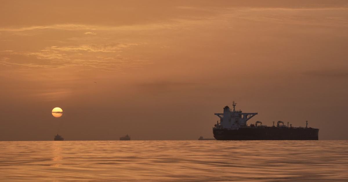The sun rises behind tankers anchored in the Strait of Hormuz off the coast of Qeshm Island, Iran, Saturday, April 18, 2026 (AP Photo/Asghar Besharati)