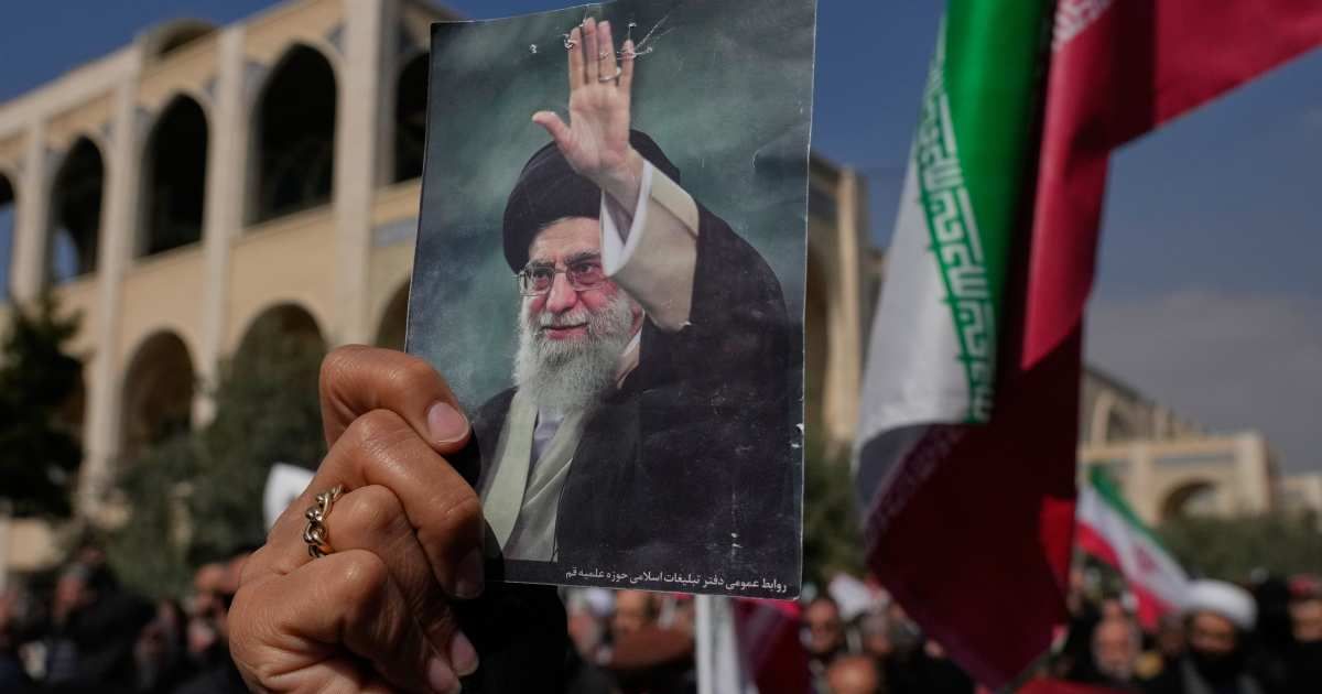 A woman holds up a picture of the late Iranian Supreme Leader Ayatollah Ali Khamenei as government supporters march against the ongoing US-Israeli military campaign at the Imam Khomeini Grand mosque in Tehran, Iran, Friday, March 6 (AP Photo/Vahid Salemi)