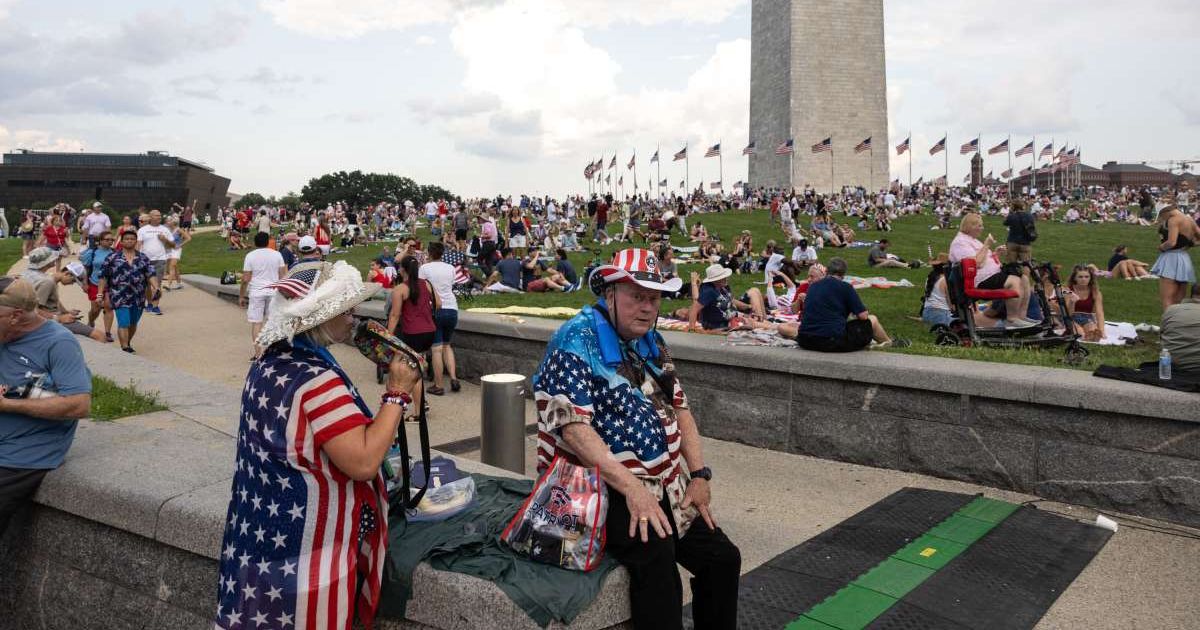 People sit near the Washington Monument ahead of the 'Salute to America 250' rally on the National Mall during a celebration of America's 250th Independence Day on July 4, 2026, in Washington, DC (Anna Rose Layden/Getty Images)