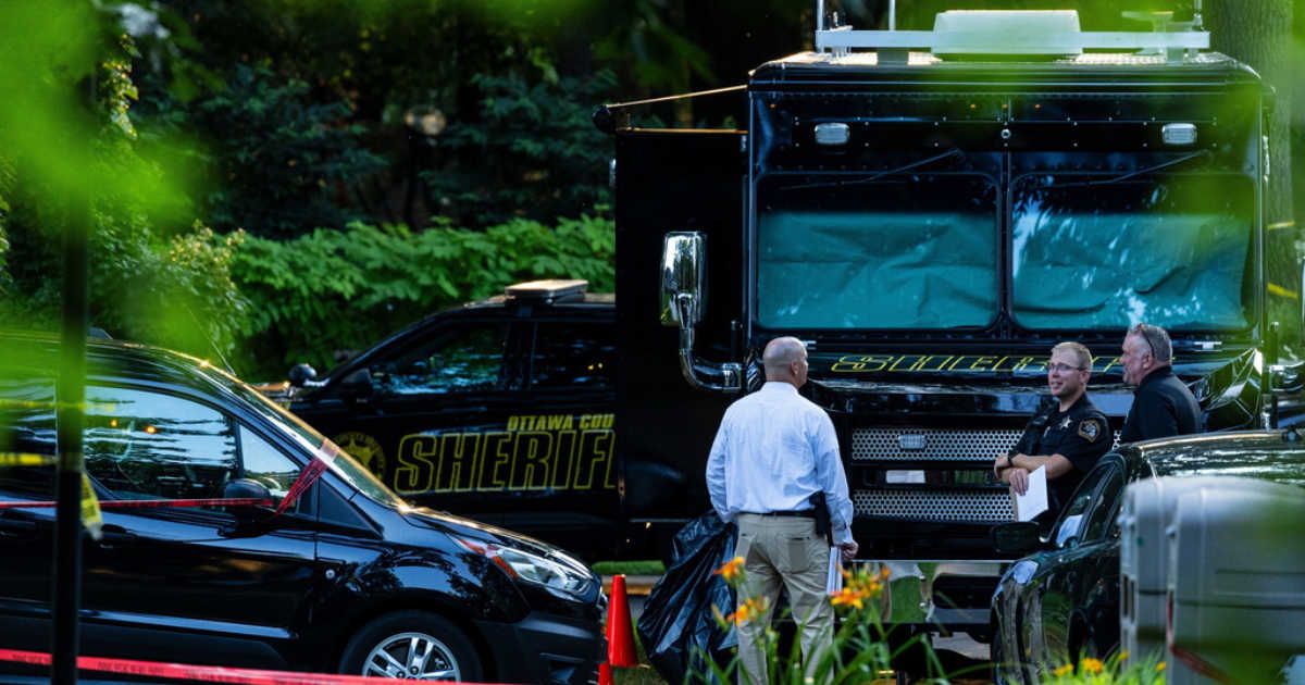 Law enforcement officials investigate the scene of a fatal house fire on Friday, July 24, 2026, in Grand Haven Township, Michigan (Joel Bissell/Kalamazoo Gazette via AP)