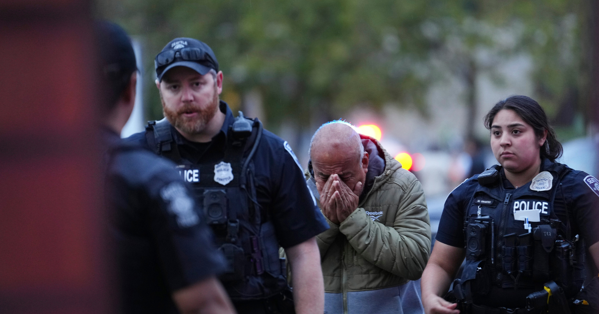 An unidentified man is led into the scene by police after they responded to a shooting at Seattle Center during the Bite of Seattle food festival Sunday, July 26, 2026, in Seattle, Wash