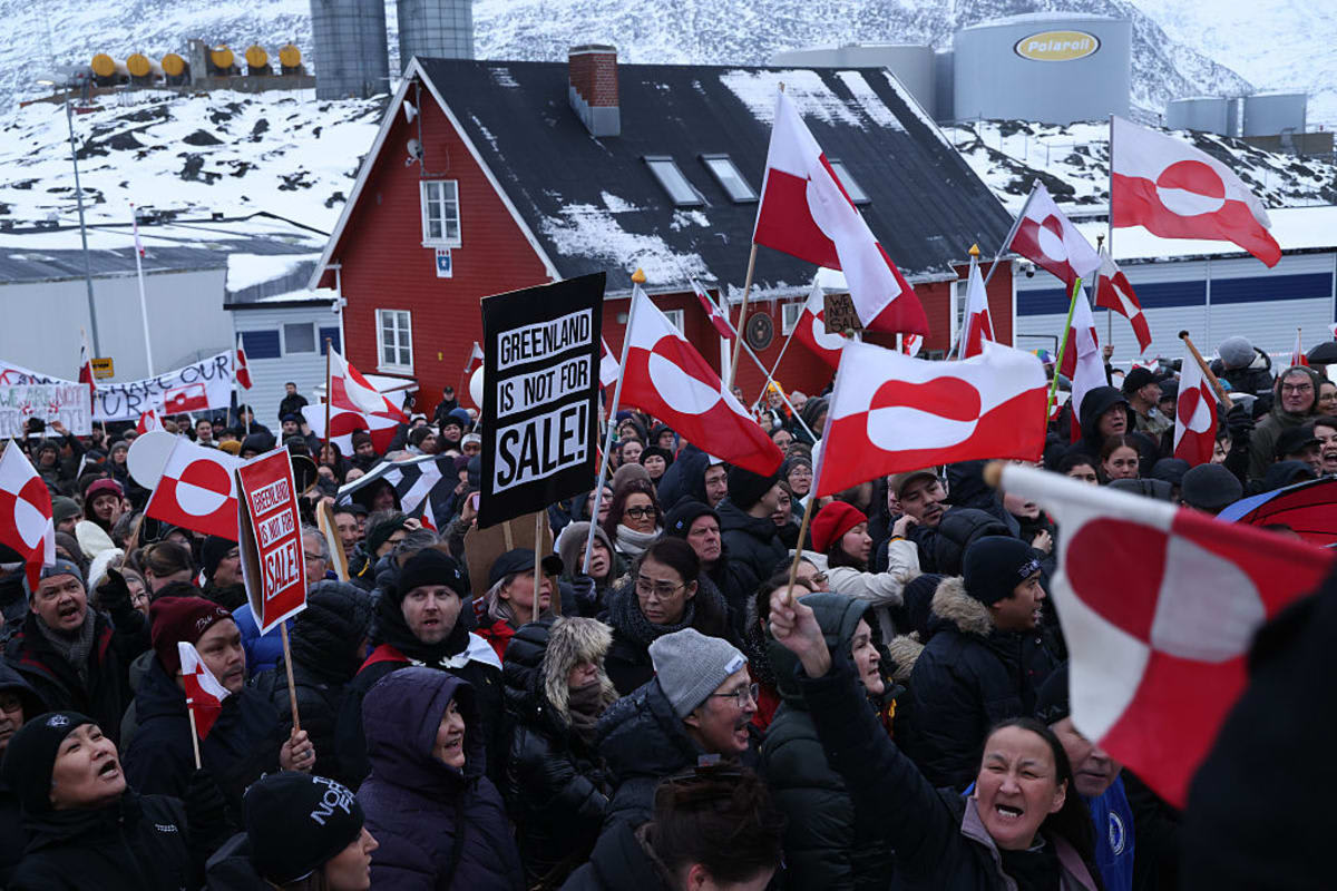 People bear Greenlandic flags as they gather in front of the U.S. consulate protest against U.S. President Donald Trump and his announced intent to acquire Greenland on January 17, 2026 in Nuuk, Greenland. Greenlandic, Danish and other European leaders are hoping they can still avert an intervention by the United States to forcefully acquire the island as U.S. President Donald Trump continues to insist the U.S. must have Greenland, suggesting even by military means if necessary. (Photo by Sean Gallup/Getty Images)