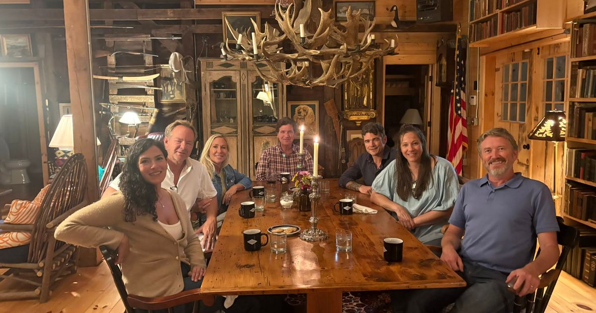 Marjorie Taylor Greene shared a photo showing herself, partner Brian Glenn, Tucker Carlson, Thomas Massie, Joe Kent, and their spouses seated around a dining table (@FmrRepMTG/X)