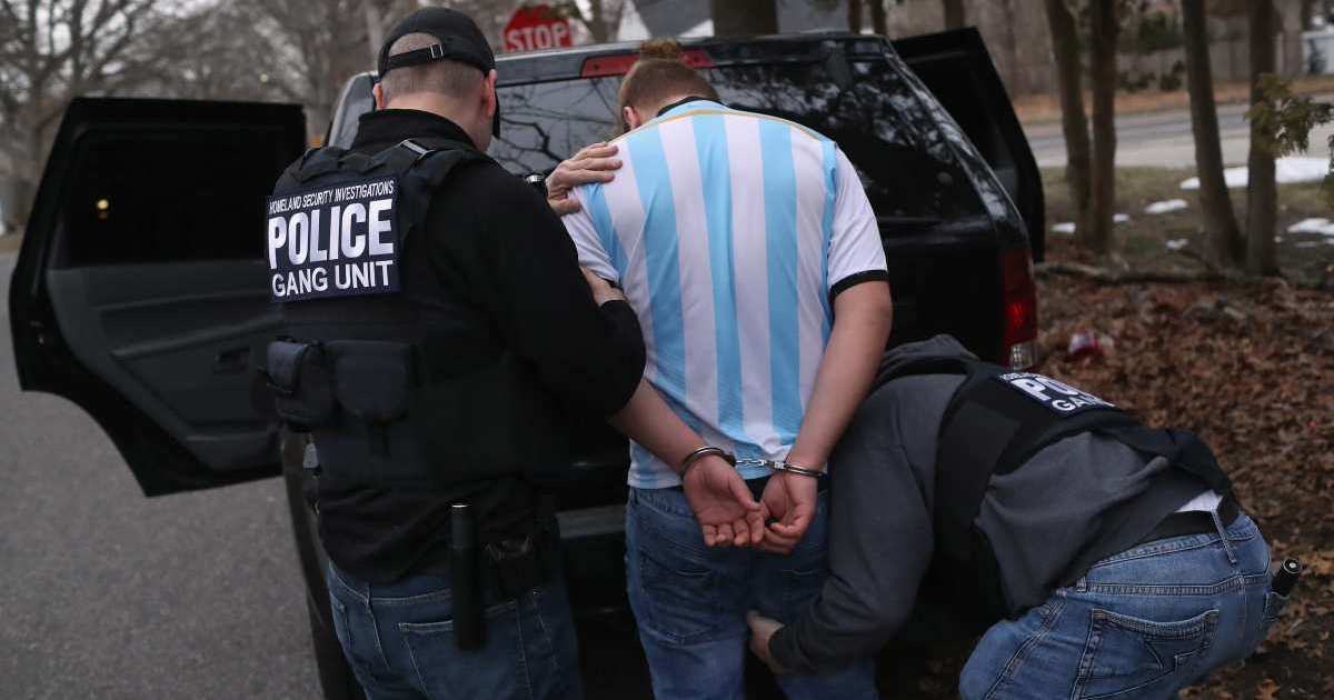 Homeland Security Investigations (HSI) ICE agents frisk a suspected MS-13 gang member and Honduran immigrant after arresting him at his home on March 29, 2018 in Brentwood, New York (Getty Images)