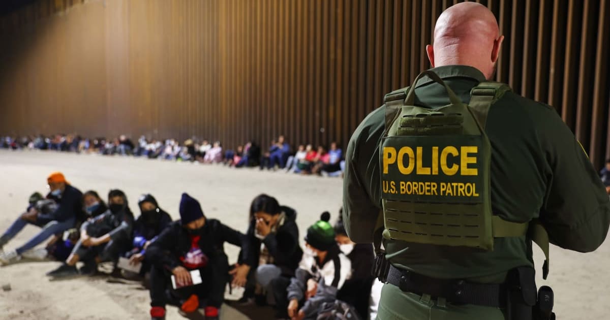 A Border Patrol agent checked immigrants' passports after they crossed the US-Mexico border in Yuma, Arizona, on May 18, 2022 (Getty Images)