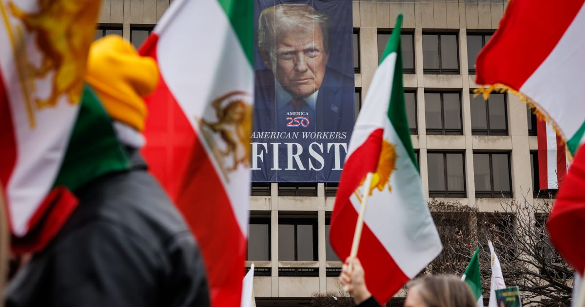 Protestors march past a banner depicting President Donald Trump on the side of the Department of Labor during a rally on March 7, 2026, in Washington, DC (Getty Images)