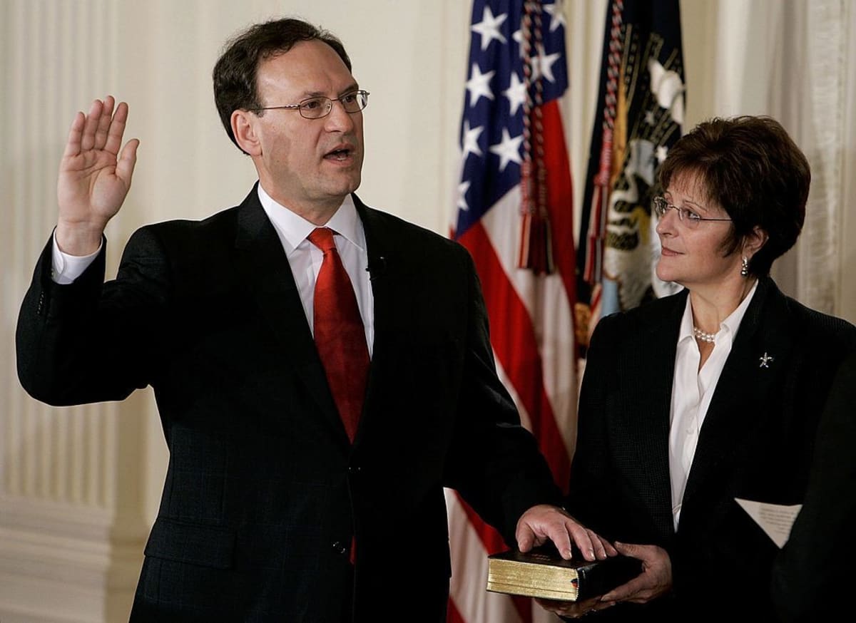 Samuel Alito (L) is sworn in as Associate Justice of the U.S. Supreme Court as his wife Martha-Ann Bomgardner holds a bible during a ceremony in the East Room at the White House February 1, 2006 in Washington, DC. The U.S. Senate voted in favor of Alito earlier in the week to become Associate Justice of the highest court in the United States. (Photo by Mark Wilson/Getty Images)